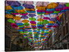 Immerse yourself in the enchanting view of a street adorned with a cascade of vibrantly colored umbrellas, each casting an alluring dance of shades and tones. This artwork, captured in high definition, invites the observer into a whimsical world where rain is celebrated and streets are transformed into mesmerizing canvases of color. 