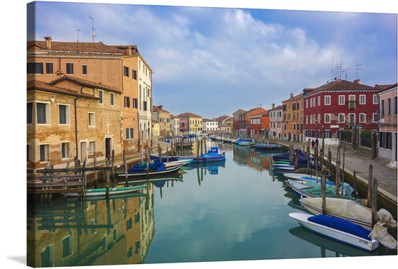 This stunning print of a canal in Venice, Italy is a must-have for art lovers. The photo-realistic image showcases the city’s iconic canals and architecture. The buildings are a mix of different architectural styles and colors, and the water is a beautiful shade of blue-green and is very still.