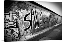  Immerse yourself in the evocative allure of “Berlin Wall” by David Lally, a limited edition print that encapsulates the potent mix of history, art, and social commentary. This monochromatic masterpiece captures a segment of the iconic Berlin Wall, adorned with graffiti that is as provocative as it is artistic. 