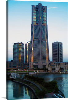  The artwork captures a majestic skyscraper standing tall amidst the serene cityscape. As dusk falls, the building’s intricate architecture is accentuated by the gentle play of lights, casting an enchanting glow that reflects off the tranquil waters below. This artwork encapsulates the harmonious blend of urban development and natural beauty.