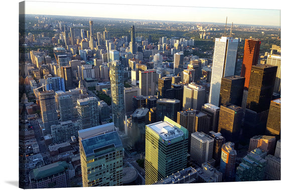 This print captures the breathtaking view of a cityscape during the golden hour. Skyscrapers, their glass facades reflecting the serene beauty of the sky, stand tall and proud against the backdrop of a sky transitioning from day to night. Amidst the concrete jungle, pockets of green spaces indicate parks or gardens within the city. 