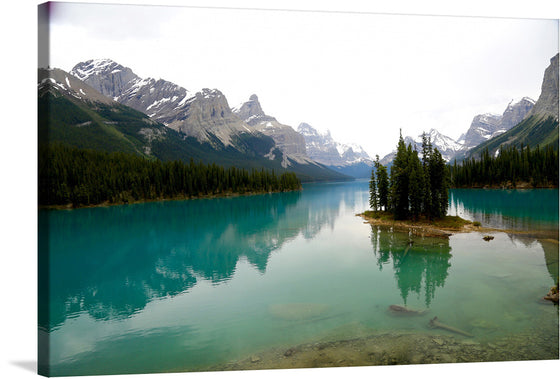 “Lake Panorama” by Jean Beaufort is a captivating print that encapsulates the tranquil beauty of nature. The image features a pristine, turquoise lake, nestled amidst towering, snow-capped mountains. The lake houses a small, forested island at its heart, serving as a serene focal point. The calm waters mirror the majestic peaks and lush greenery, creating a harmonious reflection that adds depth to the scene. 