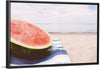 "Half of a watermelon on the beach"