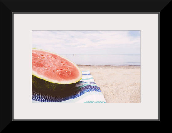 "Half of a watermelon on the beach"