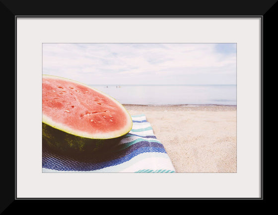 "Half of a watermelon on the beach"