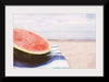 "Half of a watermelon on the beach"