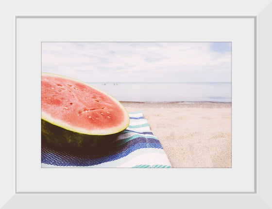 "Half of a watermelon on the beach"