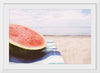 "Half of a watermelon on the beach"