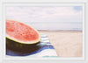 "Half of a watermelon on the beach"