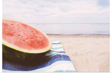  "Half of a watermelon on the beach"