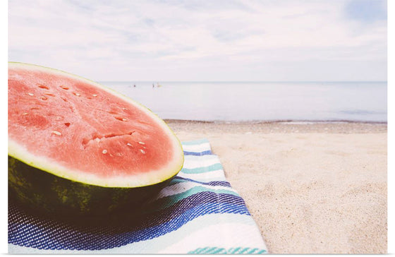 "Half of a watermelon on the beach"