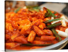  Immerse yourself in the vibrant and appetizing allure of this exquisite print, capturing a delectable dish that is a feast for both the eyes and the soul. Each element, from the succulent, glazed pieces of tteokbokki basking in their rich, red sauce to the crisp, green vegetables offering a refreshing contrast, is rendered with meticulous detail. 
