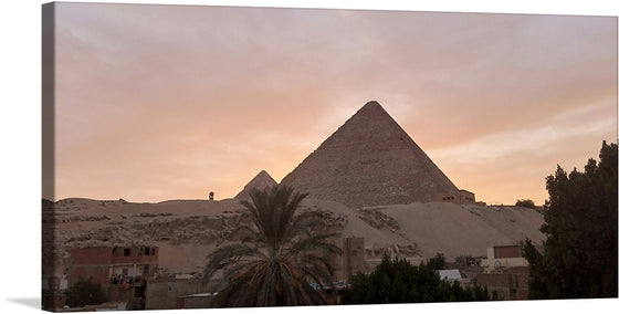 This image is a stunning photograph of a large pyramid sitting on top of a hill. The pyramid is made of smooth, white stone, and it is surrounded by a lush green landscape. The sky is a light orange and purple, and the sun is setting.