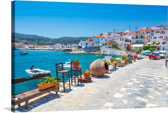“Kokkari” is a captivating print that transports you to a picturesque seaside village. The artwork captures the essence of the Mediterranean paradise with its azure waters reflecting the clear skies, quaint white buildings adorned with terracotta roofs, and lush green hills in the background under clear blue skies.