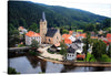 “Rozmberk, Czech Republic” is a captivating print that transports you to a peaceful European village nestled amidst lush greenery. The artwork captures the charming scene of colorful houses, a historic church with an elegant steeple, and the tranquil river that flows gracefully through the town. 