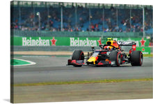  Capture the exhilarating speed and precision of Formula 1 racing with this stunning print! Every detail, from the sleek design of the race car adorned in vibrant colors to the blurred background capturing its rapid motion, brings the thrill of the race into your space. The distant spectators and prominent Heineken® advertisements immerse you in a world where engineering and adrenaline coalesce. 