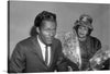 “Chuck Berry en Lucy Ann (1965)” by Joop van Bilsen is a striking black and white photograph that captures the essence of the era. The image features two blurred figures, one in a suit and the other in a hat and veil, with a bouquet of flowers. This print would make a great addition to any collection of vintage photography or mid-century art".