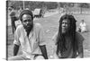 This black and white print is a snapshot of the Anti-Apartheidsfestival in Ganzenhoef, Amsterdam. It features two individuals sitting on a grassy field. The photo captures the mood of the festival and the people who attended it. The photo was taken by Roland Gerrits in 1986 and is available for purchase as a print. 