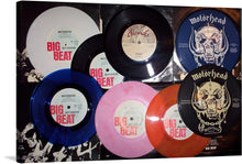  This exclusive artwork is a harmonious assembly of iconic Motorhead vinyl records, each piece meticulously arranged against a visually striking backdrop that echoes the raw, unfiltered essence of rock ‘n’ roll. The records, labeled “BIG BEAT” and “MOTORHEAD”, are displayed in different colors: white, black, blue, pink, and orange.