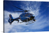 This artwork titled “Police Helicopter” is a captivating print that encapsulates the synergy of technology and the boundless sky. The artwork captures a police helicopter in mid-flight, its blue body gleaming against a backdrop of wispy clouds scattered across the azure sky. 