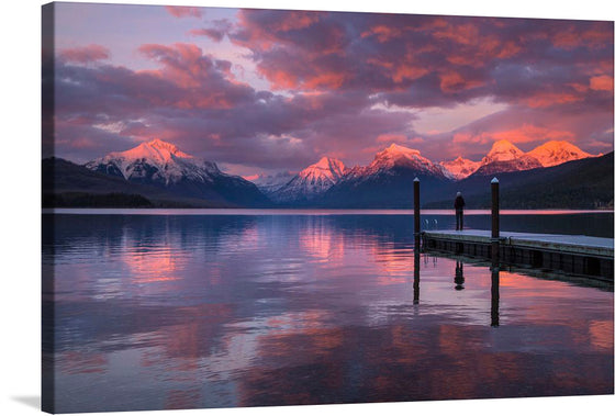Immerse yourself in the serene beauty of this exquisite print capturing a tranquil moment at dusk. The majestic mountains, kissed by the setting sun, cast a warm glow that dances on the placid waters of the lake. A lone figure stands on a wooden dock, enveloped in the awe-inspiring embrace of nature’s grandeur. Every detail, from the vibrant hues of the sunset sky to the gentle ripples in the water, is rendered with stunning clarity to transport you to this peaceful haven.
