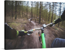  This print captures the thrilling perspective of a mountain biker navigating through a serene forest trail. The grip on the handlebars, the blur of the passing scenery, and the winding path ahead are frozen in time, offering a glimpse into a moment of pure exhilaration. The lush greenery and the bright green bike frame invoke a sense of speed and adventure. 