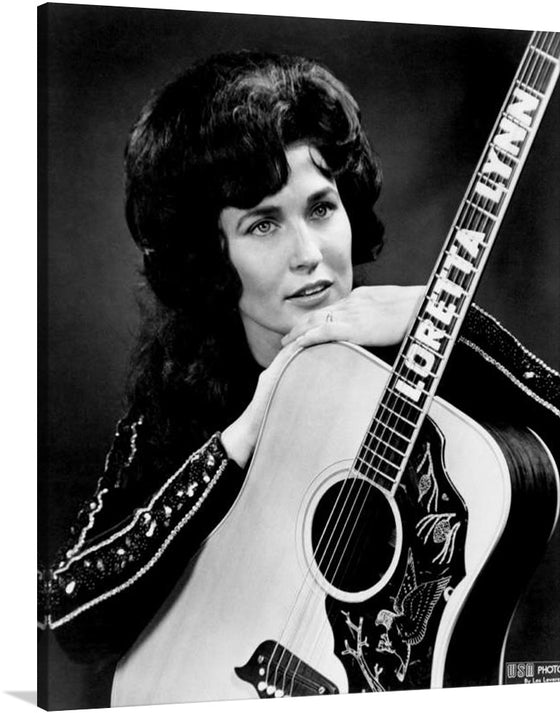 This stunning print captures the legendary Loretta Lynn, posing with her acoustic guitar in a captivatingly classic 1965 photo&nbsp;by Les Leverett. Lynn's confident expression and piercing gaze exude her signature strength and determination, while her acoustic guitar symbolizes her lifelong passion for music.