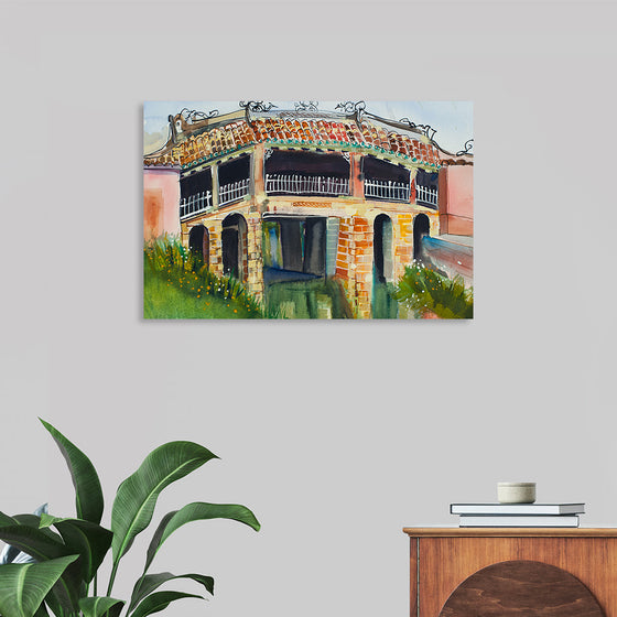 This exquisite print, titled “Japanese Bridge Hoi An”, captures the rustic charm of an old-world architectural marvel. Every brush stroke brings to life the intricate details of the brickwork and ornate railings of a bridge, while the lush greenery breathes a whisper of nature’s touch. The rich yet muted colors give it an aged and nostalgic feel, transporting you to a serene, magical world where every corner holds a story untold.