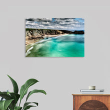  “Distant Beaches 4” by Julie Elliot invites you to escape to a coastal paradise. This captivating print captures the essence of tranquility: azure waves gently kiss the sun-drenched sands, while rugged cliffs stand as silent sentinels to the dance of the clouds above. 