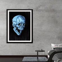  “The Blue” by Marta Tesoro invites you into the enigmatic allure of a hauntingly elegant skull. Against a stark black backdrop, this mesmerizing artwork bathes the skull in an ethereal blue hue. Every intricate detail, from the hollow eyes to the intricately etched bones, tells a story of life, death, and the beauty that lies therein. As a print, “The Blue” promises to be more than mere decoration; it’s a conversation starter, an evocative piece that marries gothic charm with contemporary artistry. 