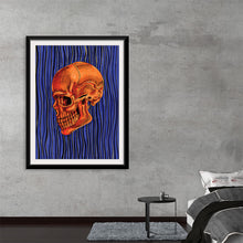  Dive into a world where art and emotion intertwine with “Orange” by Marta Tesoro. This mesmerizing print captures the essence of human complexity, featuring an intricately detailed orange skull against a backdrop of deep blue waves, symbolizing the eternal dance between life and death. A bold, red square overlays part of the skull, injecting a modern touch that challenges traditional perspectives on art and existence. 