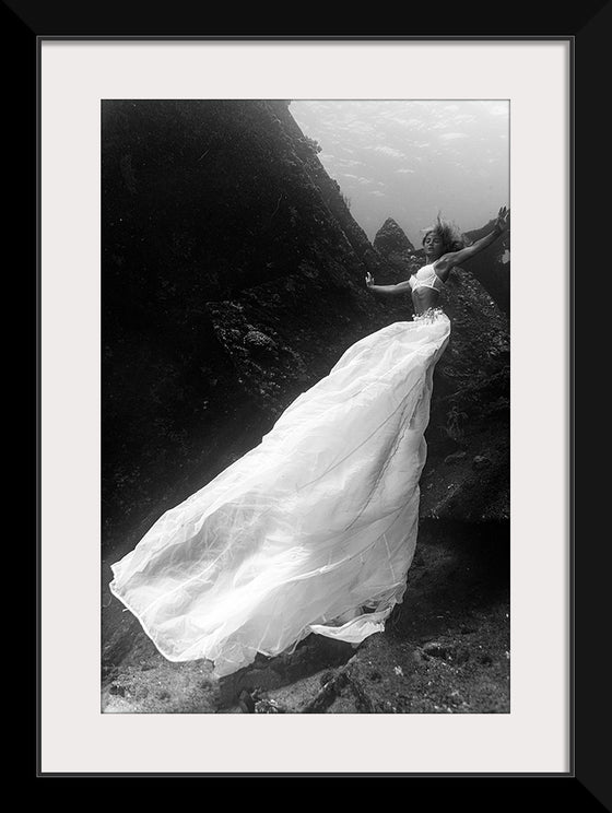 “Underwater Animals – An Ocean Bride 4” by Victor Hawk is a mesmerizing monochromatic artwork that captures the serene beauty of nature in its most tranquil state. The print, available as a limited edition, invites you into an ethereal underwater world where elegance meets the wild beauty of the ocean. A figure, enveloped in gossamer fabrics, dances gracefully amidst the currents, evoking the mystical allure of underwater wonders.