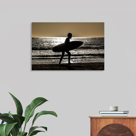 “Abstraction – Beach 5” by Victor Hawk invites you to a tranquil shore, where the sun’s golden kiss meets the rhythmic embrace of the waves. In this sepia-toned masterpiece, a lone surfer carries their board along the beach, leaving footprints in the sand. The ocean, captured mid-motion, whispers tales of adventure and serenity. 