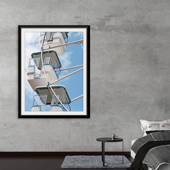 Elevate your space with this mesmerizing print, “Close Up of a Ferris Wheel”. Every detail of the iconic amusement ride is captured with pristine clarity, from the intricate lines of its steel framework to the inviting seats waiting to lift guests into the sky. Set against a backdrop of soft clouds and azure skies, this piece invites a sense of nostalgia and wonder, making it a perfect addition for those looking to infuse an element of joy and whimsy into their surroundings.