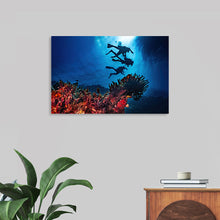  “Underwater Animals – Divers Above the Corals 2” by Victor Hawk invites you to plunge into the mystical depths of the ocean. This exquisite print captures the serene beauty of underwater life, juxtaposed with the adventurous spirit of divers exploring this hidden world. The vibrant corals, teeming with life, are illuminated by beams of sunlight piercing through the water’s surface, casting an ethereal glow on the divers above. 