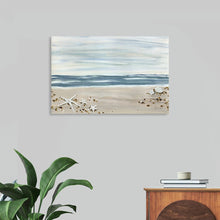  “Shells by the Shore” by Yvette St. Amant: Immerse yourself in the tranquil allure of a pristine beach with this exquisite print. Yvette St. Amant’s masterful brush strokes bring to life the dance of light on water and sand. Against a backdrop of gentle waves, delicate seashells adorn the sandy shores. Each shell, meticulously rendered, tells a story of nature’s elegance. The soft blues, whites, and beige tones evoke calmness and serenity.