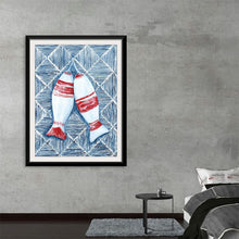  Dive into the serene and intricate world of Yvette St. Amant’s “Nautical Fish Buoys”. This exquisite print captures the tranquil beauty of two fish buoys, adorned in red and white, floating amidst a sea of mesmerizing blue patterns. Every stroke, every detail, is a testament to St. Amant’s mastery in bringing nautical charm to life. 